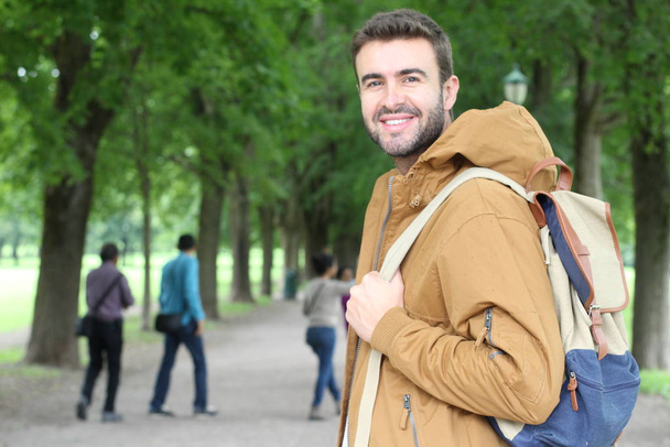 Un homme tendance portant une tenue d'hiver souriante dans le parc - Photo, image