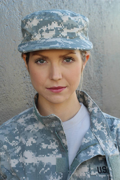 Gorgeous young woman in a Military costume on gray background - Foto, imagen