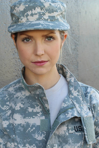 Gorgeous young woman in a Military costume on gray background - Foto, Bild
