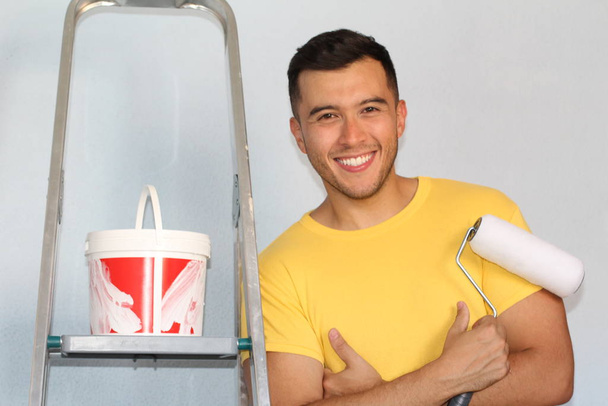 Joyful ethnic male about to paint a wall in his home - Φωτογραφία, εικόνα
