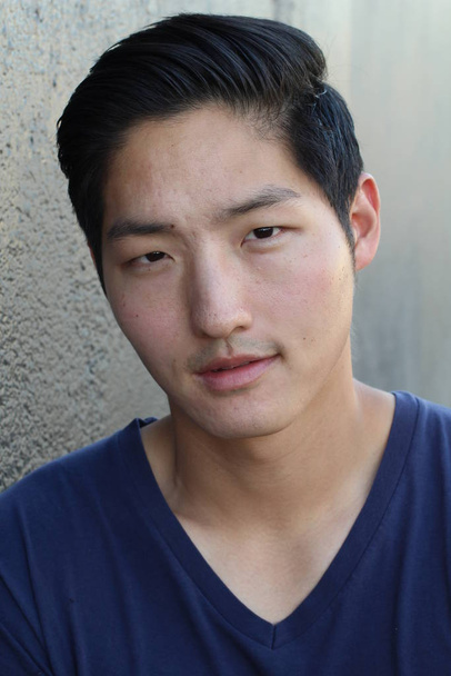 close-up portret van knappe jonge aziatische man in blauw shirt - Foto, afbeelding