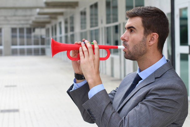 Rumoroso uomo d'affari che suona una tromba di plastica
 - Foto, immagini