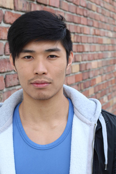 close-up ritratto di bello giovane asiatico uomo di fronte al muro di mattoni
 - Foto, immagini