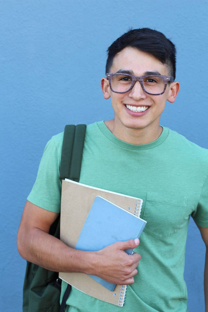 κοντινό πορτραίτο όμορφου νεαρού μαθητή με σακίδιο μπροστά από τον μπλε τοίχο - Φωτογραφία, εικόνα