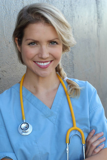 Profesionales médicos: Enfermera sonriendo mientras trabaja en el hospital. Joven hermosa rubia blanca trabajadora de la salud femenina
 - Foto, imagen