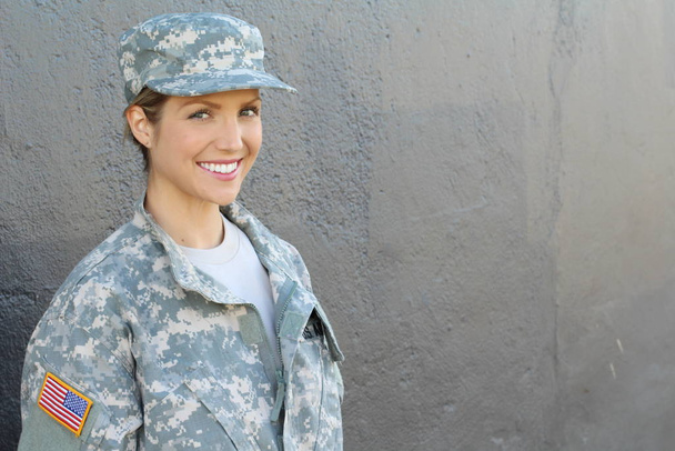 Preciosa joven con un traje militar sobre fondo gris
 - Foto, Imagen
