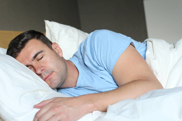 Hombre étnico profundamente dormido en cama cómoda
 - Foto, imagen
