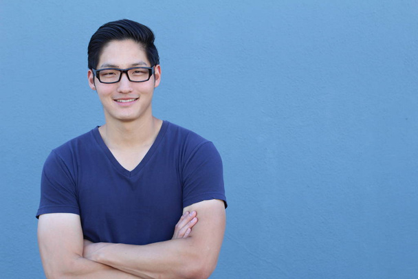 primer plano retrato de guapo joven asiático hombre en azul camisa en frente de azul pared
 - Foto, imagen