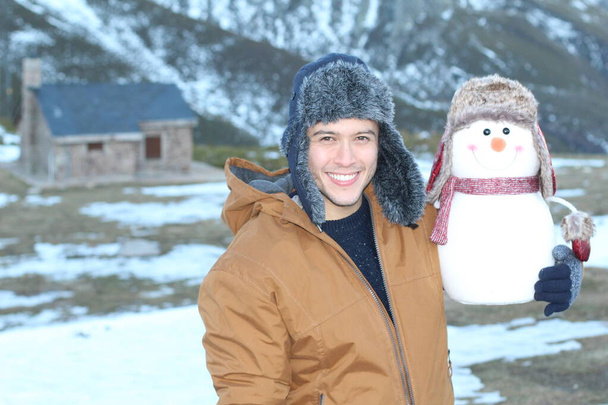 Chico caliente con un hombre de nieve lindo que se parece a él. - Foto, Imagen