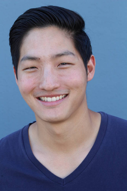 primer plano retrato de guapo joven asiático hombre en azul camisa en frente de azul pared
 - Foto, Imagen