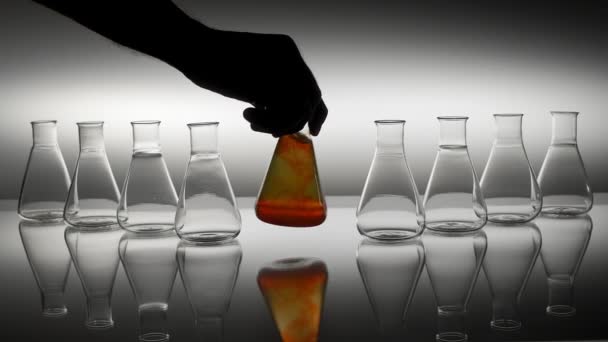 Erlenmeyer-lombik körkörösen kevert kémiai folyadékkal - Felvétel, videó