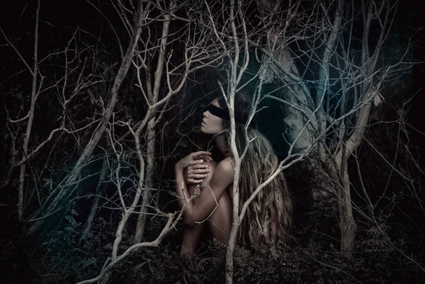 Young beautiful blindfolded woman in dark spooky forest - Foto, Imagem