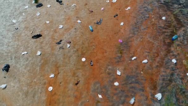 Εναέρια άποψη του ανθρώπου που στέκεται κατά μήκος πλαστικών σκουπιδιών στις όχθες του μολυσμένου ποταμού  - Πλάνα, βίντεο