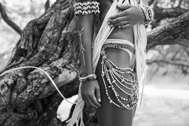 cropped image of wild boho woman in native american style and white clothes posing at nature - Zdjęcie, obraz