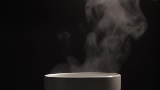 Warm gekookt water wordt gegoten met spatten in een witte keramische beker - Video