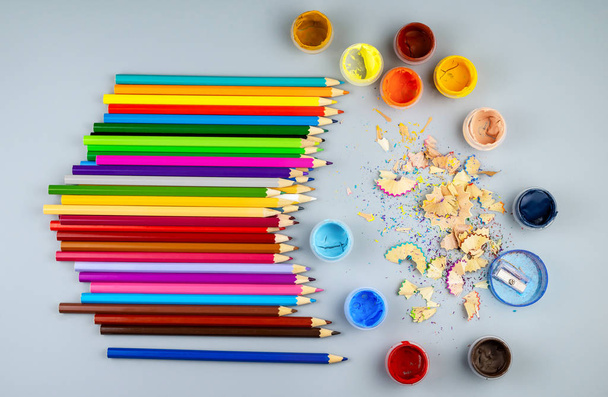 Multicolored sharpened pencils and jars with paint on a gray bac - Photo, Image