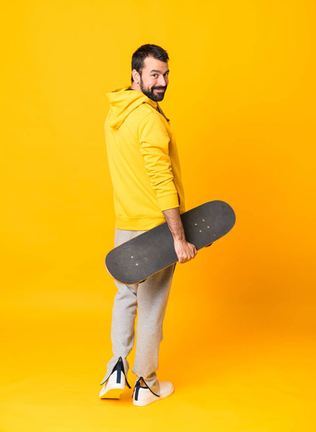 Full-length záběr bruslaře muže přes izolované žluté pozadí - Fotografie, Obrázek