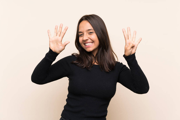 Jeune femme brune avec pull blanc sur fond isolé comptant neuf avec les doigts
 - Photo, image