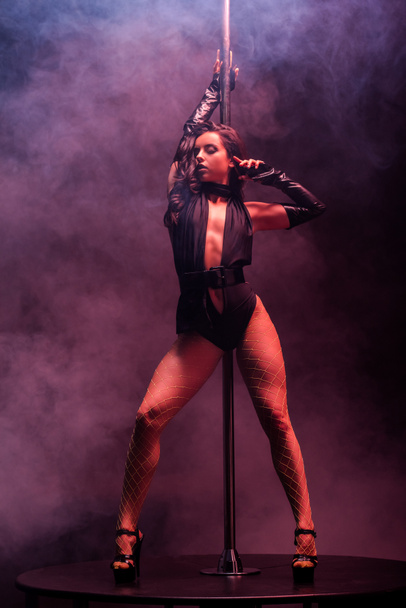 horká striptérka tančí u tyče na fialové s kouřem  - Fotografie, Obrázek