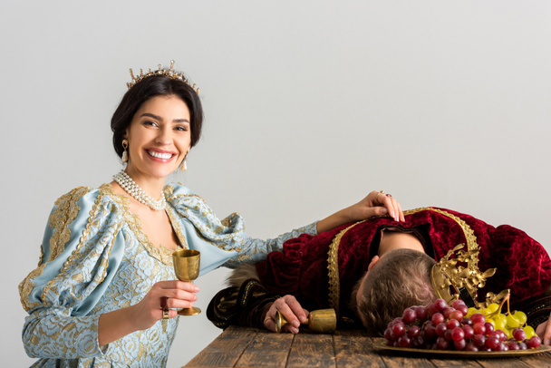 χαμογελαστή βασίλισσα με βασιλιά δηλητηρίαση στέμμα απομονώνονται σε γκρι - Φωτογραφία, εικόνα