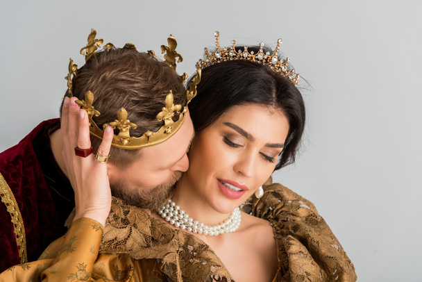 roi avec couronne étreignant et embrassant jolie reine isolée sur gris
 - Photo, image