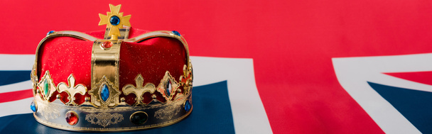 panoramic shot of golden crown on british flag  - 写真・画像