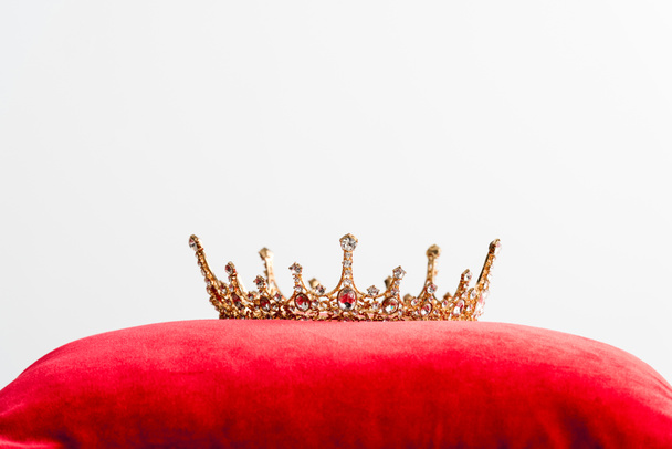 koninklijke kroon op rood kussen geïsoleerd op wit met kopieerruimte  - Foto, afbeelding