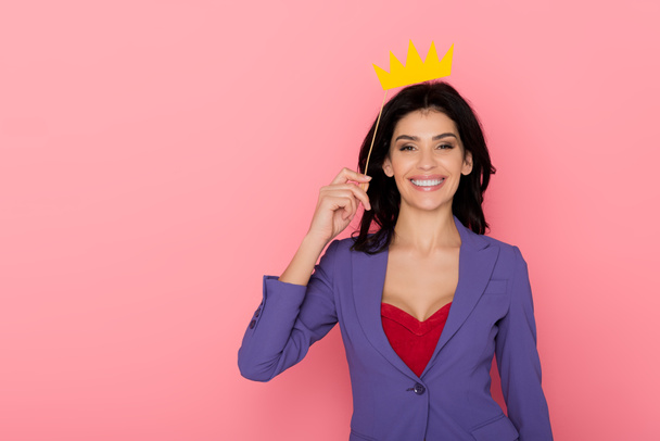 smiling woman holding paper crown on pink background  - Photo, Image