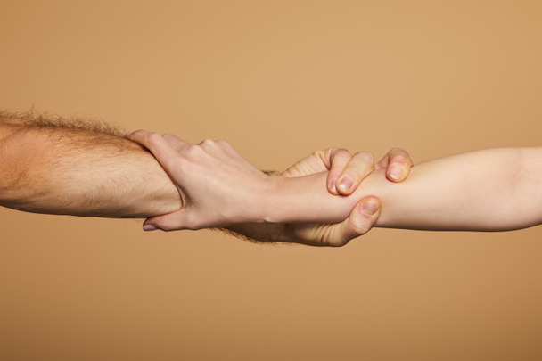oříznutý pohled na muže a ženu držící ruce izolované na béžové - Fotografie, Obrázek
