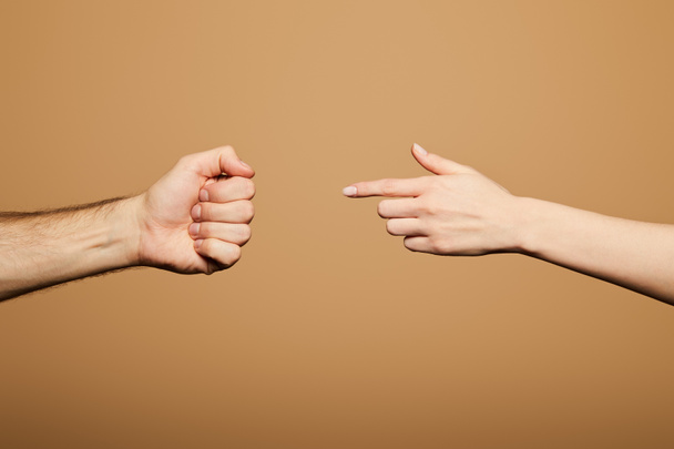 cropped view of woman pointing with finger at man fist isolated on beige - Photo, Image