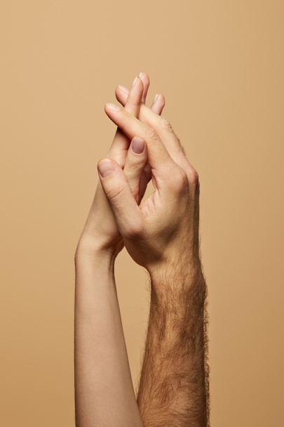 partial view of man and woman holding hands isolated on beige - Foto, afbeelding