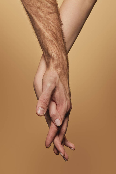 partial view of man and woman holding hands isolated on beige - Photo, image