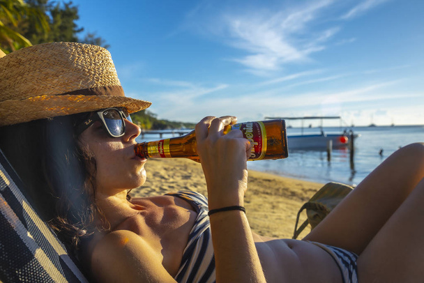 woman in straw hat with a bottle of beer - Foto, Imagem