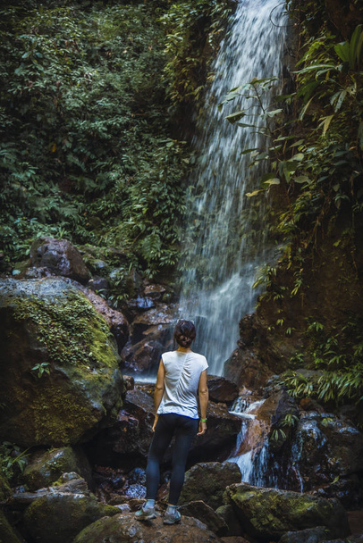woman looking at waterfall in the Cerro Azul Meambar National Park (Panacam) on Lake Yojoa, Honduras - Foto, imagen
