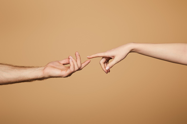 cropped view of man and woman reaching each other with fingers isolated on beige - Foto, Imagen