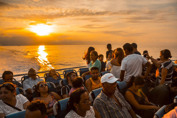 Roatan, Honduras - January 2020: tourists watching the sunset sky over Caribbean sea,  Roatan, Honduras - Photo, image