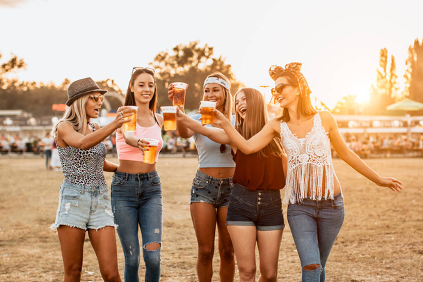beautiful young women drinking beer and having fun on music and arts festival - Foto, immagini
