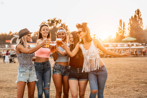 beautiful young women drinking beer and having fun on music and arts festival - Foto, imagen