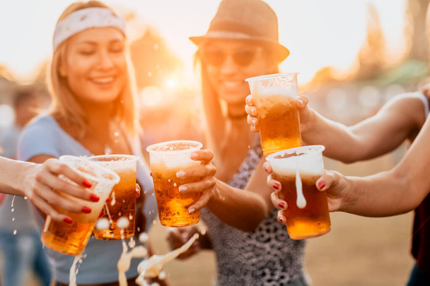 handsome young women with beer glasses celebrating start of the festival - Foto, afbeelding