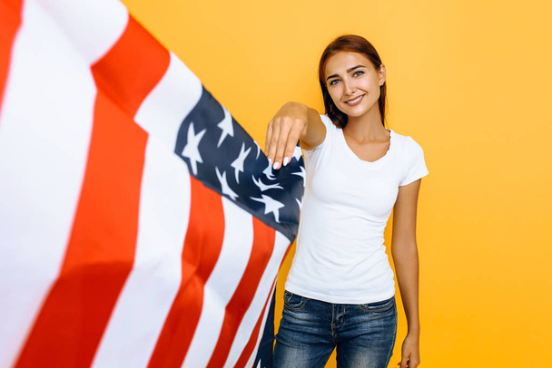 Young beautiful girl in a white t-shirt with the American flag,  - Fotografie, Obrázek