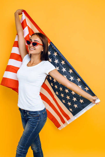 young beautiful girl in sunglasses, with American flag, having f - Zdjęcie, obraz
