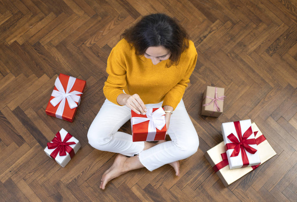 Happy young woman opening gift boxes - Foto, afbeelding