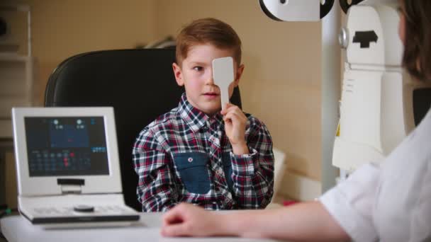 Zabieg w klinice okulistycznej - mały chłopiec zakrywający oko tarczą do oczu - Materiał filmowy, wideo