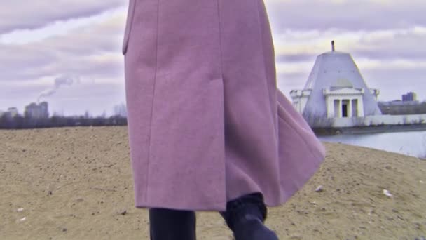 Primer plano de mujer en botas de otoño caminando sobre arena. Imágenes de archivo. Hermosa mujer joven camina a lo largo de la arena de la playa en día nublado otoño
 - Metraje, vídeo