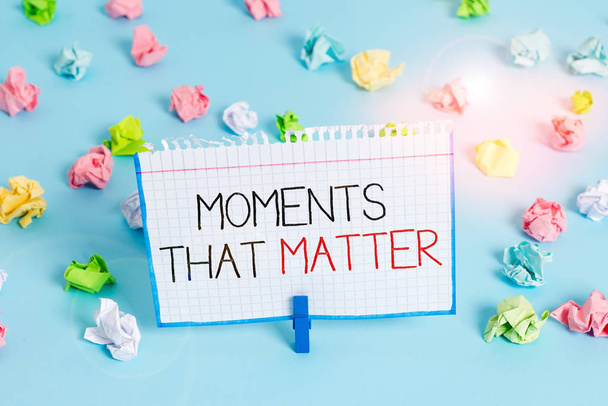 Psát text Moments That Matter. Konceptuální fotografie Významný pozitivní šťastný nezapomenutelné důležité časy Barevné zmačkané papíry prázdné připomínka modrá podlaha pozadí prádlopin - Fotografie, Obrázek