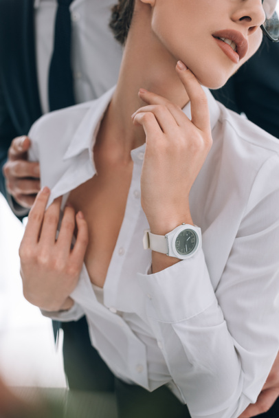 cropped view of businessman touching secretary with big breast in office  - Fotoğraf, Görsel