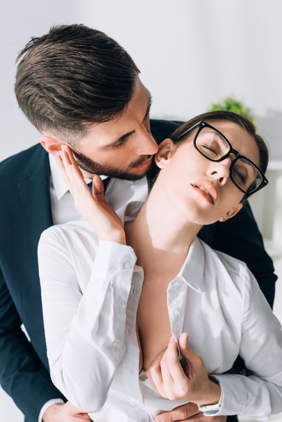 businessman kissing attractive secretary with big breast in office  - Photo, Image