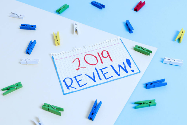 Writing note showing 2019 Review. Business concept for remembering past year events main actions or good shows Colored clothespin paper reminder with yellow blue background - Photo, Image