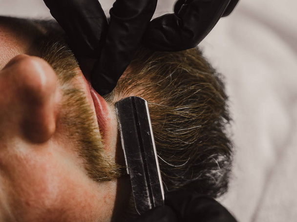 Man having beard shave in barber shop - Valokuva, kuva