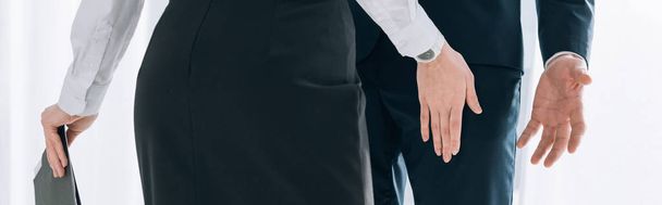 panoramic shot of secretary touching leg of businessman in office  - Фото, зображення
